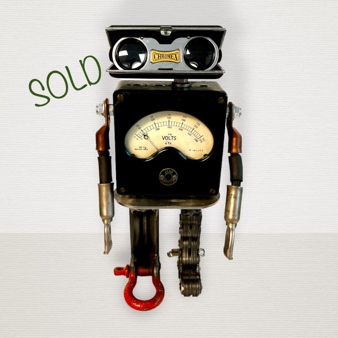 Meet Zero! This one-of-a-kind robot scrap art sculpture is made from a vintage voltmeter body, vintage pop open binocular head, uniquely reimagined electrical cable arms and scrap metal legs. Spice up your home or office décor with this unique robot sculpture.