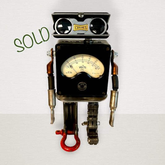Meet Zero!  This one-of-a-kind robot scrap art sculpture is made from a vintage voltmeter body, vintage pop open binocular head, uniquely reimagined electrical cable arms and scrap metal legs. Spice up your home or office décor with this unique robot sculpture.  