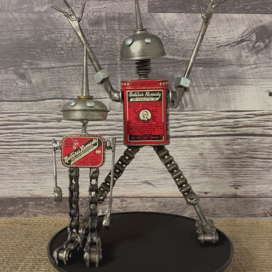 Meet Lloyd and Harry! This set of two, mischievous, one-of-a-kind robot (s)crap art sculptures are both made from matching vintage Nature's Remedy laxative tins for their bodies, oiler heads, (s)crap metal arms and chain legs. Spruce up any shelf in your home, restroom ;) or office with these two unique robot sculptures.  