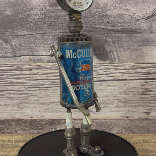 Meet McCulloch! This one-of-a-kind robot scrap art sculpture is made from a vintage outboard motor oil tin body, a vintage carbon dioxide gauge head with uniquely reimagined scrap metal arms and spark plug legs. Kick back and relax with this slippered little scrap bot!   See video for 360 degree view!  Features:   Height: 28 cm or 11 inches tall Width: approximately 7.5 cm or 3 inches wide Weight: 0.635029 kg or 1.4 lbs