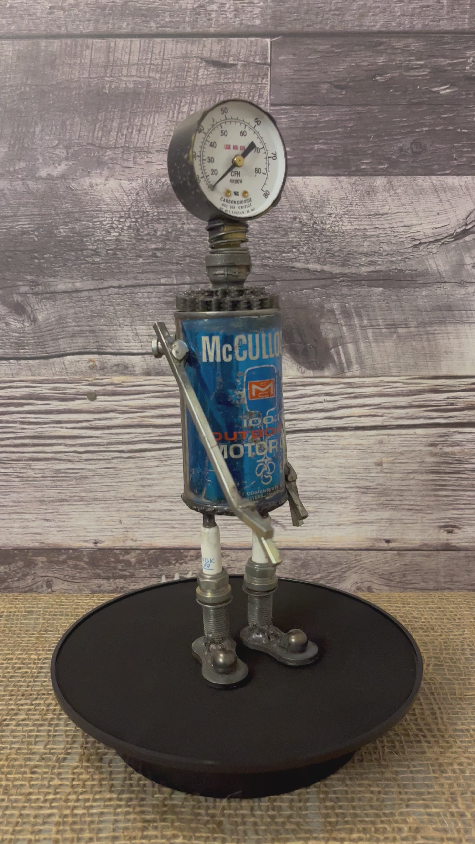 Meet McCulloch! This one-of-a-kind robot scrap art sculpture is made from a vintage outboard motor oil tin body, a vintage carbon dioxide gauge head with uniquely reimagined scrap metal arms and spark plug legs. Kick back and relax with this slippered little scrap bot!   See video for 360 degree view!  Features:   Height: 28 cm or 11 inches tall Width: approximately 7.5 cm or 3 inches wide Weight: 0.635029 kg or 1.4 lbs