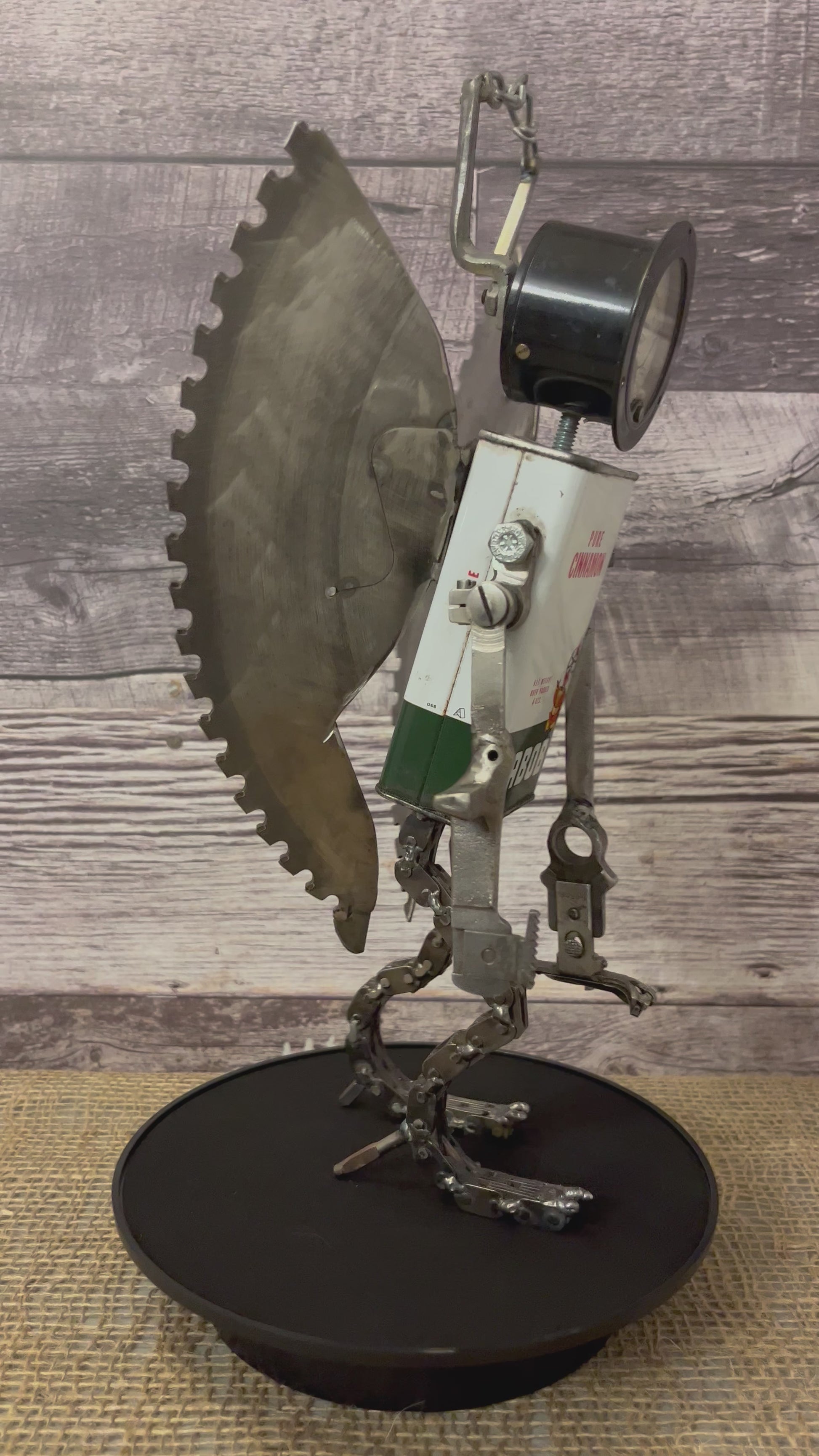 Meet Angel!  This one-of-a-kind robot scrap art sculpture is made from a vintage cinnamon tin body, vintage gauge head with uniquely reimagined scrap metal arms made from vintage Singer sewing machine parts, chain legs and saw blade wings.  Your very own guardian angel robot! See video for a 360-degree view! Features:  •	Height: 35 cm or 13.75 inches tall  •	Width: approximately 18 cm or 7 inches wide •	Weight: 1.17934 kg or 2.6 lbs.