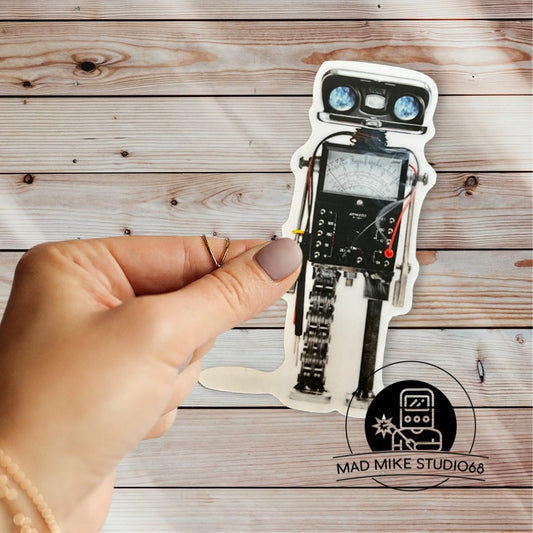 This cute little custom die cut robot scrap art sticker is made of permanent white semi gloss vinyl and measures as follows:  Features:  Metric: 3.81 cm wide x 8.89 cm tall Imperial: 1.5 inches wide x 3.5 inches tall Collect them all!