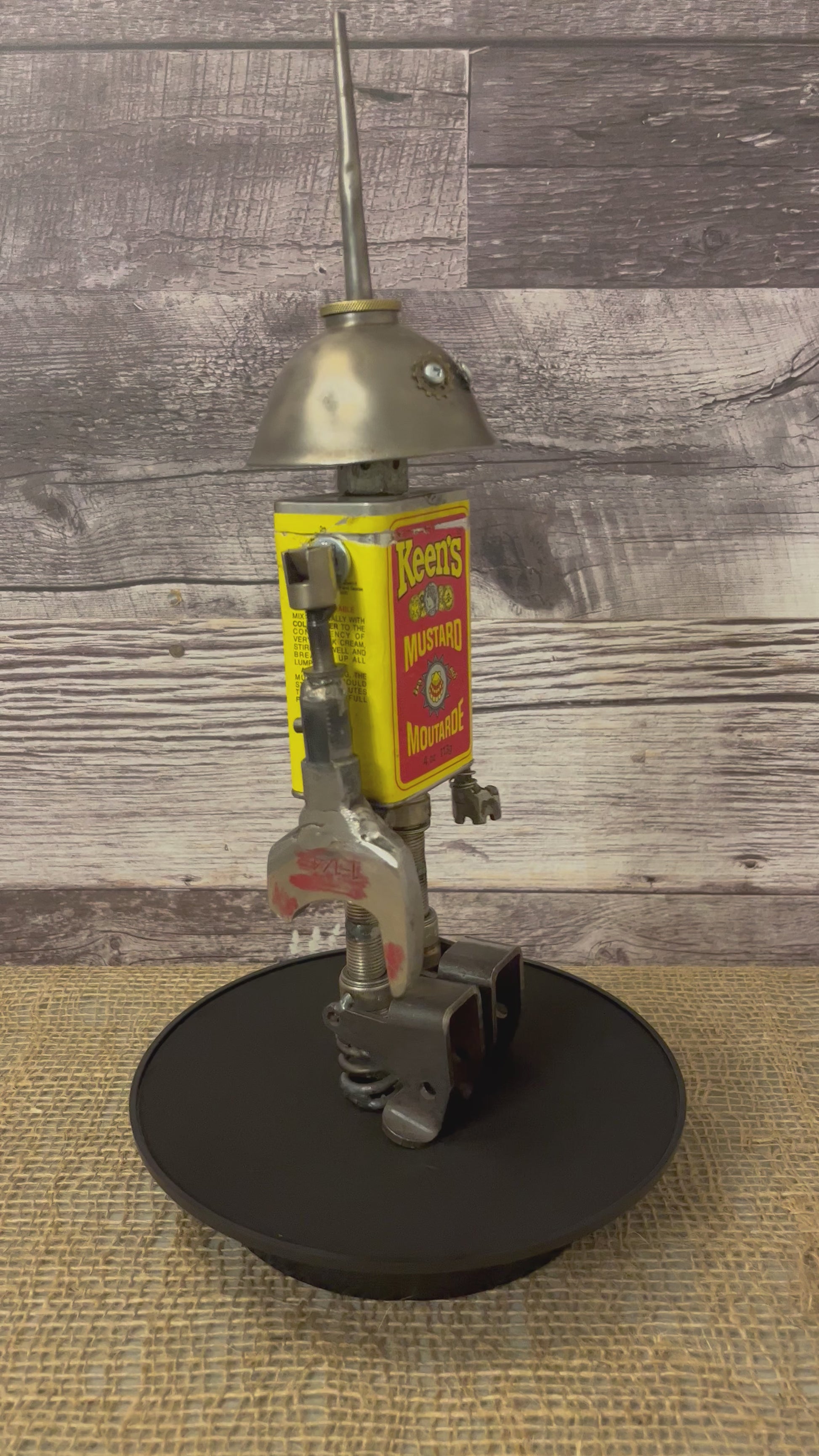 Meet Keener! This one-of-a-kind robot scrap art sculpture is made from a vintage spice tin body, vintage oiler head with uniquely reimagined scrap metal arms and spark plug legs. This adorable little scrap bot is beaming with personality!  See video for a 360-degree view!  Features:   Height: 36 cm or 14 inches tall Width: approximately 10 cm or 4 inches wide Weight: .907 kg or 2 lbs